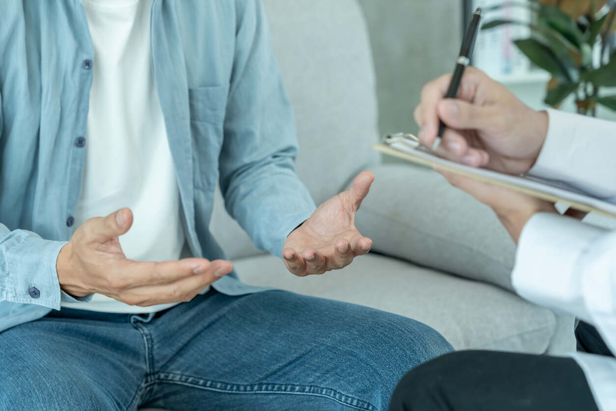 Close-up of a person during a first family law mediation session, discussing concerns with a mediator taking notes