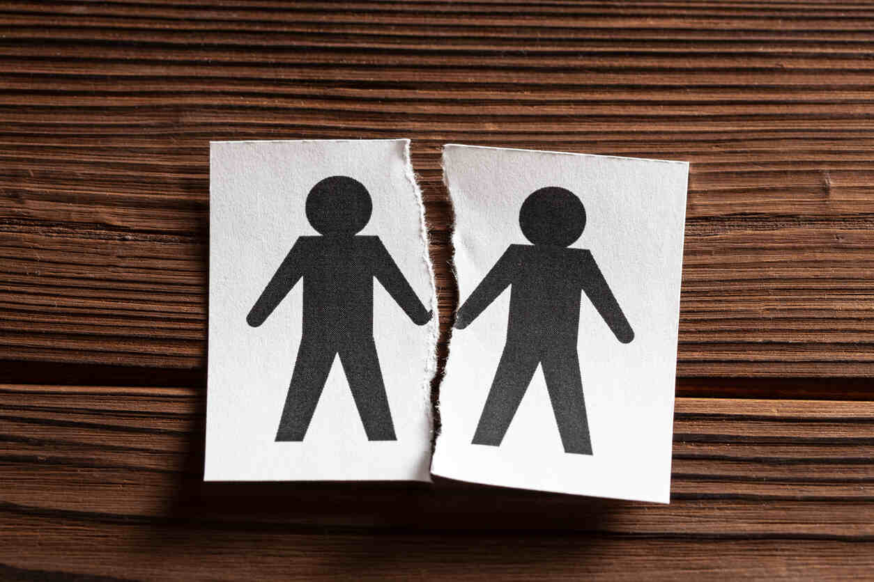 Two torn paper cutout figures, symbolizing separation for same-sex couples seeking family law mediation in California.