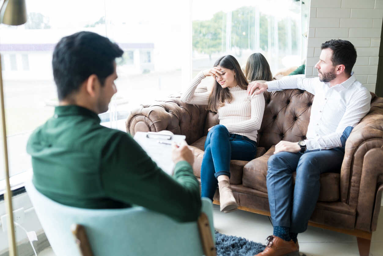 Mediator with a couple on a sofa, symbolizing family law mediation services in Oakland.