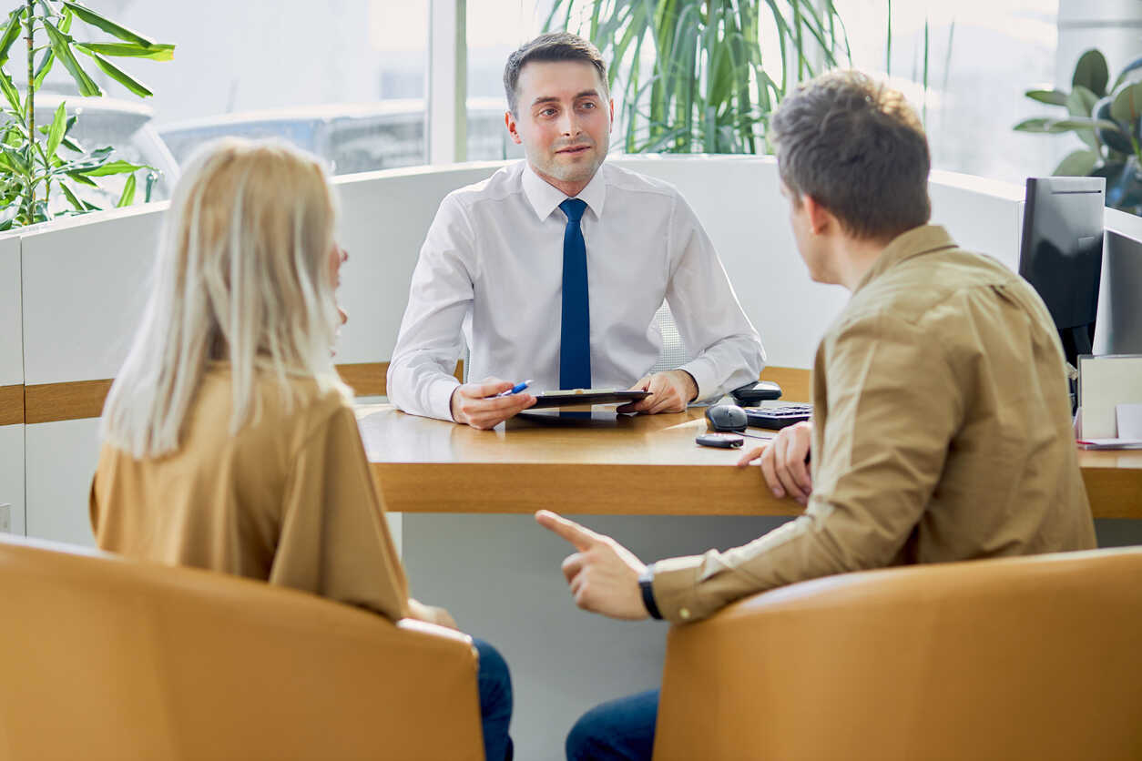 A male mediator speaking with a couple at a table, representing mediation services in Long Beach.